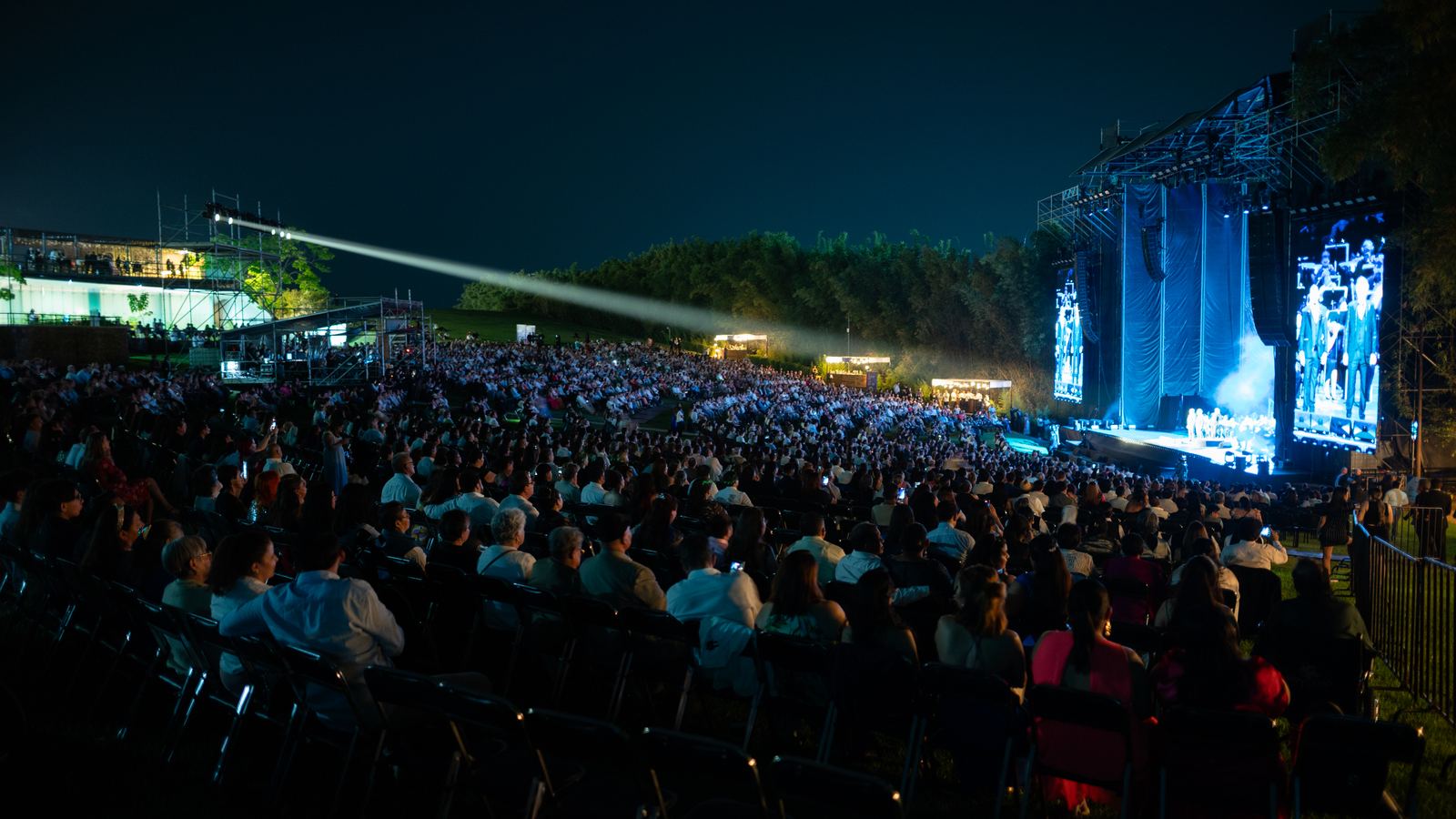 Concierto nocturno al aire libre en Jardines de México, Morelos: escenario con pantallas LED, iluminación y miles de asistentes
