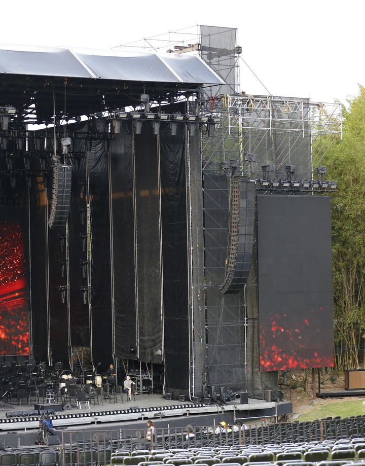 Montaje de escenario con torres de audio, pantallas LED y estructura de andamios