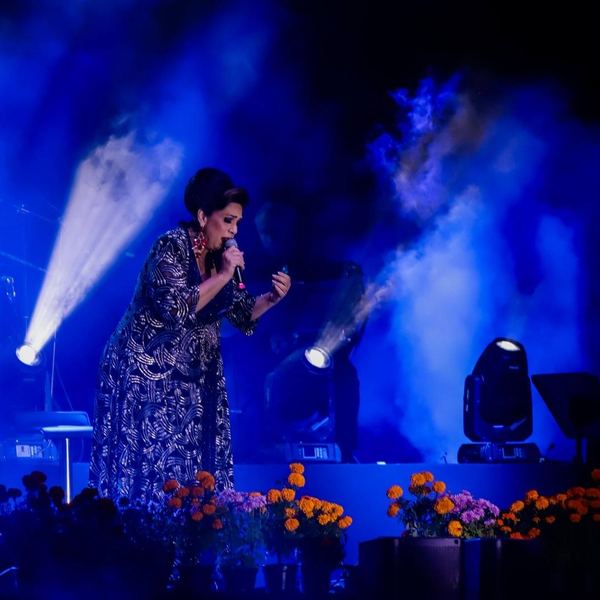 Cantante en el escenario con iluminación azul y humo