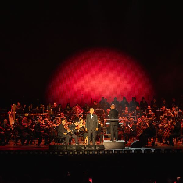Orquesta en un escenario iluminado de rojo durante un concierto nocturno en Jardines de México, Morelos