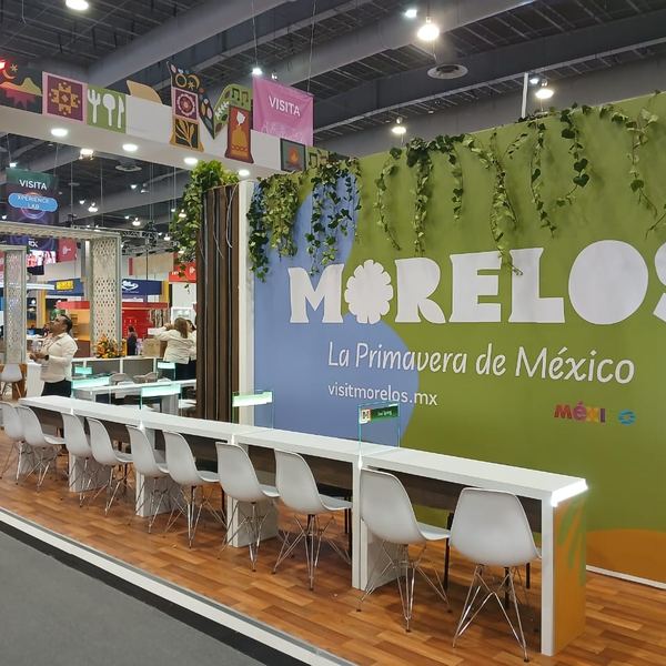 Stand de Morelos con barra y sillas blancas en una feria de turismo