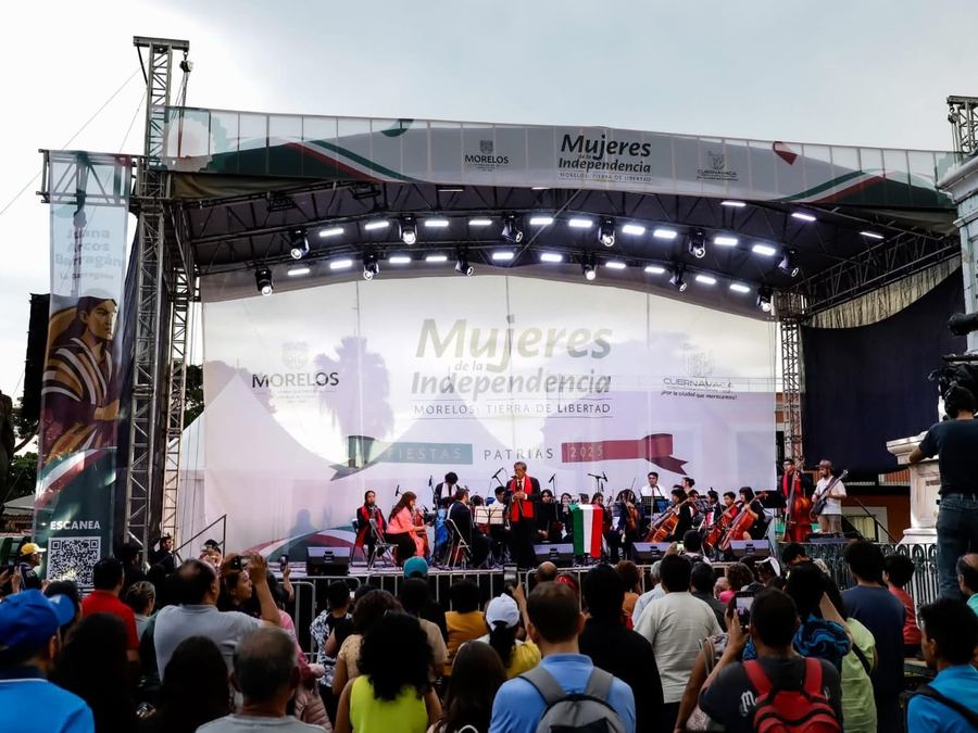 Escenario con techo de estructura y lona impresa en una plaza pública llena de asistentes