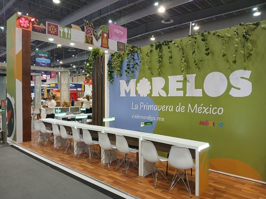 Stand de Morelos con barra y sillas blancas en una feria de turismo